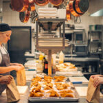 Equipe de dark kitchen organizando pedidos em linha de produção, com cozinha profissional estruturada para delivery e foco em eficiência operacional.